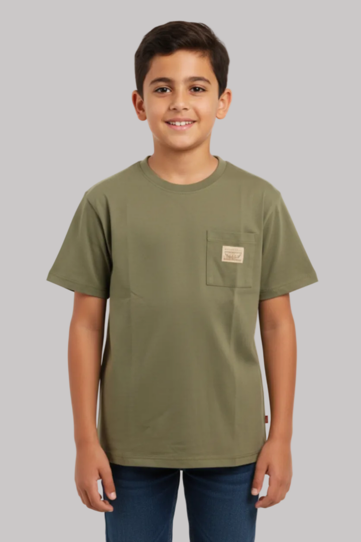 Young boy wearing an olive green t-shirt with a pocket on a white background